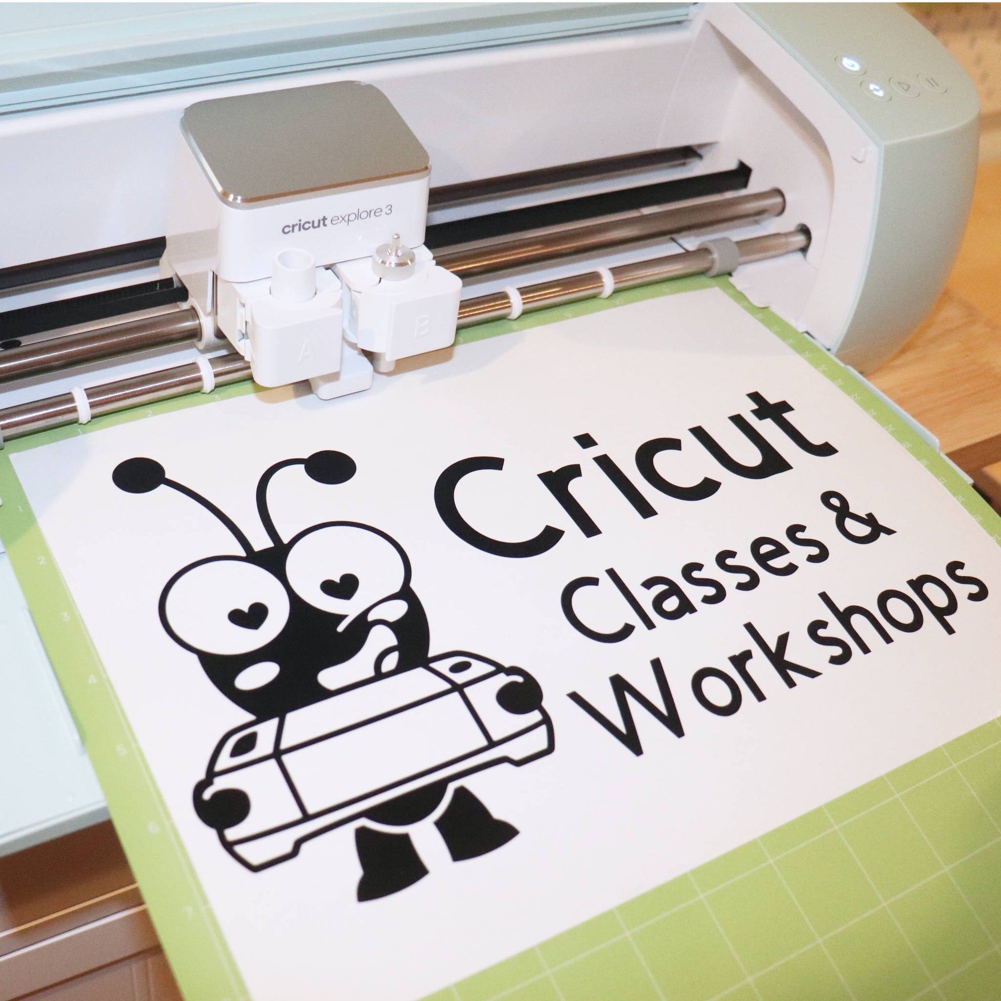 Cricut machine with a medium tack mat holding a project. Cricut Cutie holding a machine and words that read Cricut Classes and Workshops